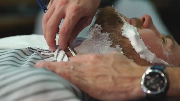 Клієнт під час гоління бородою в перукарні — стокове відео