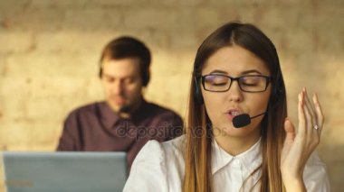 Sana arka planda erkek meslektaşı ile bir parlak ofis ortamında gülümseyen Merkezi kadın icra akıllı genç ara