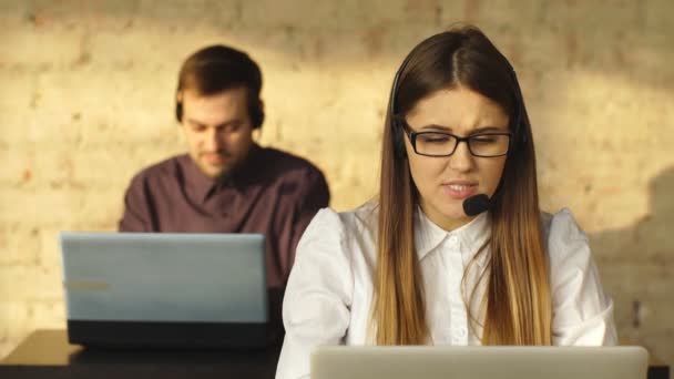 Man and woman in headphones working in call center — Stock Video