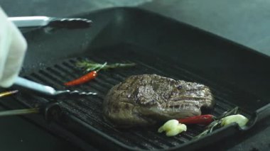 Şef biftek Maşa ile çevirir.