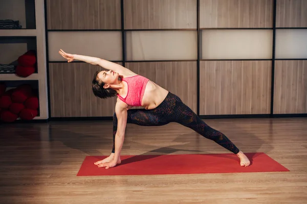 Jonge mooie brunette yoga poseren op een studio — Stockfoto