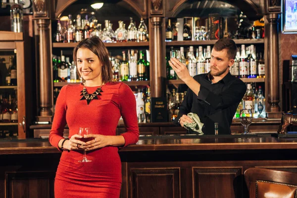 Красивая женщина стоит рядом с коктейлем в баре — стоковое фото