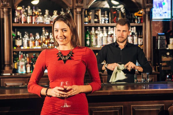 Красивая женщина стоит рядом с коктейлем в баре — стоковое фото