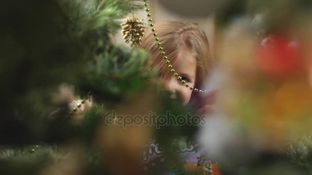 Niña escondida detrás del árbol de Navidad — Vídeos de Stock