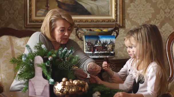 Бабушка с двумя детьми готовится к Рождеству — стоковое видео
