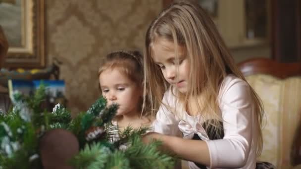 Dos niñas hacen una corona de Navidad — Vídeo de stock