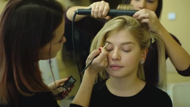 Makyaj yapma işlemi. Fırça ile çalışma modeli yüzünde makyaj sanatçısı. Sarışın genç kadın güzellik salon portresi Inter — Stok video