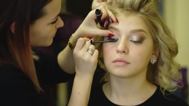 Καλλιτέχνης μακιγιάζ, δημιουργώντας όμορφα μακιγιάζ για το ξανθό μοντέλο — Αρχείο Βίντεο