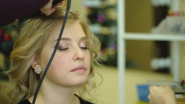 Truccatore creando un bel trucco per il modello bionda — Video Stock