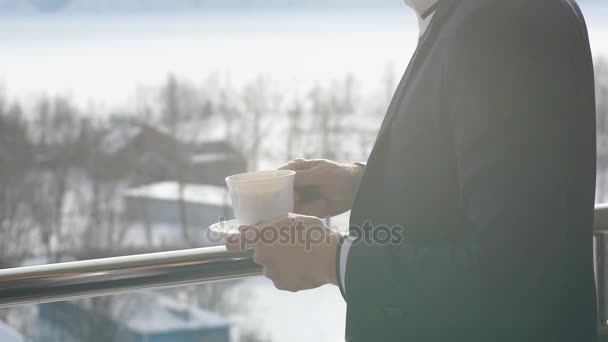 Hombre tomando café en el balcón con montañas en el fondo — Vídeo de stock