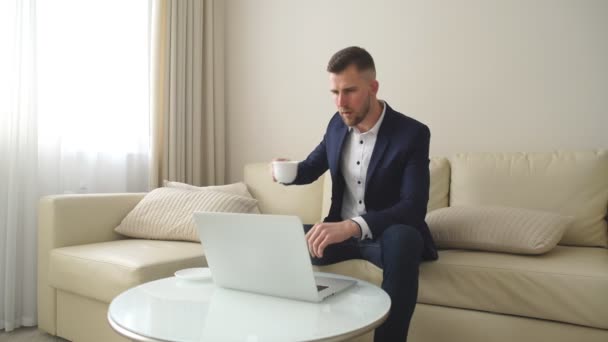 Geschäftsmann entspannt sich zu Hause im Wohnzimmer, er sitzt auf dem Sofa — Stockvideo