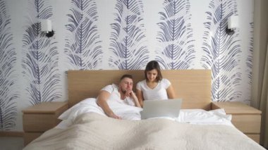 evde yatakta yatarken bir bilgisayar kullanılarak Çift