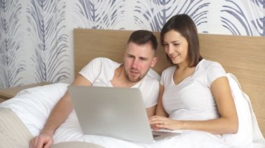 yatakta film izlerken laptop ile genç Çift