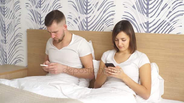 Couple avec smartphones au lit — Video