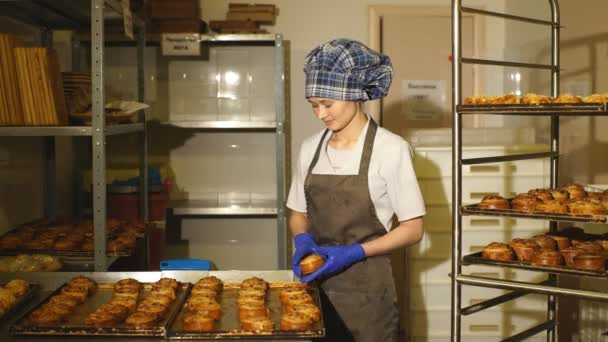 Baker permanent in zijn bakkerij in de ochtend en is het bakken van brood of broodjes — Stockvideo