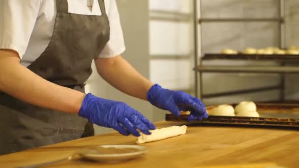 Μια ευτυχής φούρναρης θηλυκό κάνοντας κανέλα κυλά. Κάνει ψωμάκια κανέλλας — Αρχείο Βίντεο