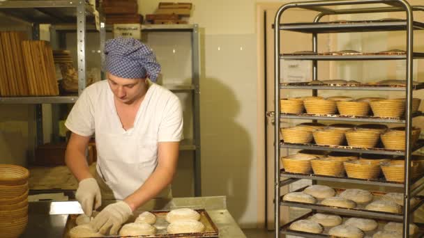 Un boulanger fait des incisions manuelles sur la pâte pour le pain. La fabrication du pain. Boulangerie — Video