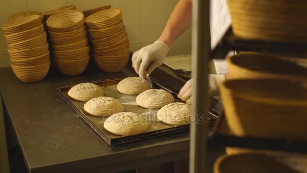 Un panettiere fa incisioni manuali sulla pasta per il pane. La fabbricazione di pane. Panificio — Video Stock