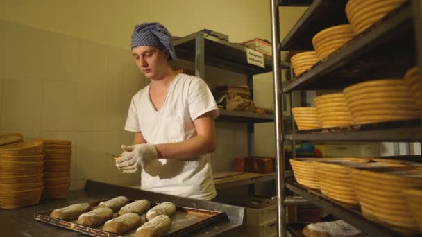 A Baker makes manual incisions on the dough for the bread. The Manufacture Of Bread.Bakery — Stock Video