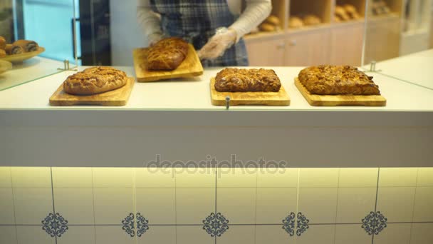 Гостинна дружня дівчина зі смачними вершковими пирогами у пекарні — стокове відео