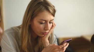 genç güzel kadın telefon bir kafede kullanır.