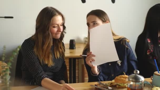 Vackra flickor skratta på ett kafé — Stockvideo