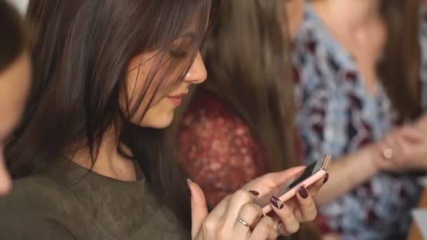 Jovem mulher bonita usa o telefone em um café — Vídeo de Stock