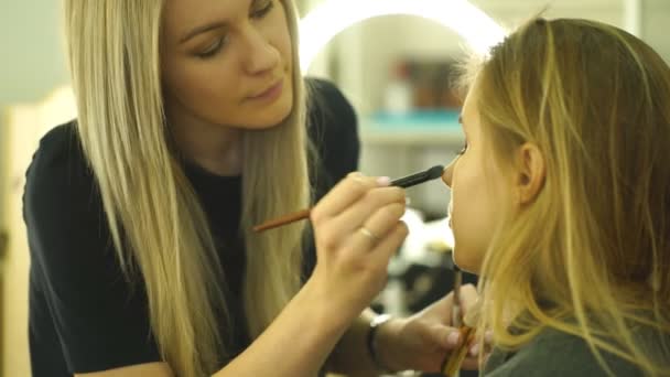 Proceso de hacer maquillaje. Maquillaje artista que trabaja con cepillo en la cara del modelo . — Vídeos de Stock