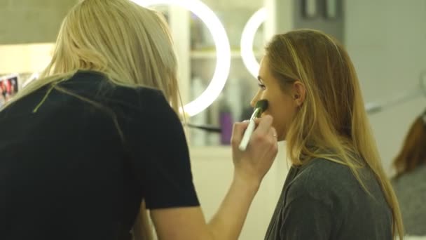 Makeup artist creating beautiful makeup for blonde model — Stock Video