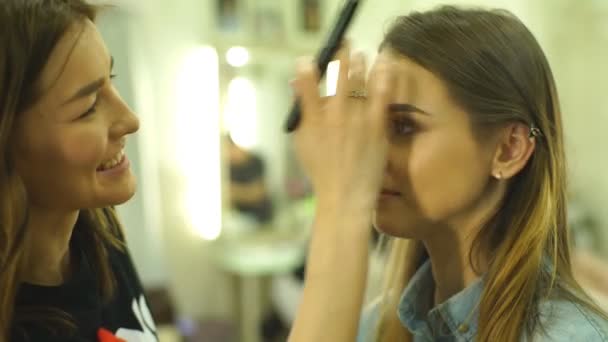 Maquiagem artista criando maquiagem bonita para modelo morena — Vídeo de Stock