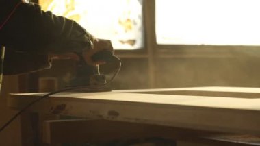 Ahşap sander zımpara. Öğütücü ile çalışan bir adam. Talaş altından tekerlek uçtu