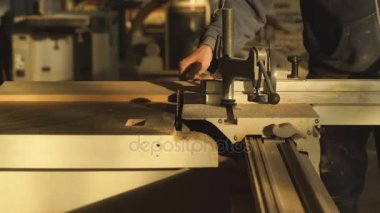 Bir tahta üzerinde bir elektrikli testere makinesi ile marangoz