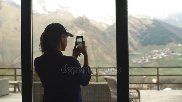 Женщина-туристка фотографирует горы по телефону — стоковое видео
