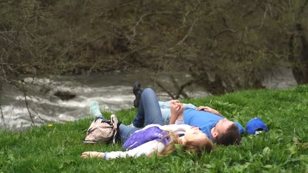 Νεαρό ζευγάρι για το φόντο ενός βουνού ποταμού στη γεωργία — Αρχείο Βίντεο