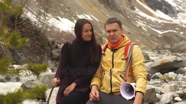 美しいカップルの山の石の上に座って、景色を愛でる — ストック動画