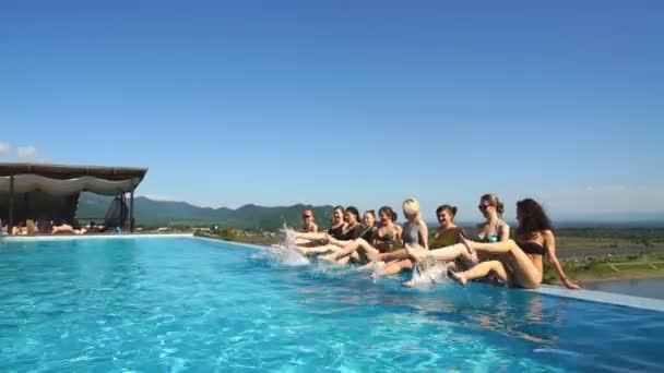 Grupo de mujeres sentadas en fila en el lado de la piscina — Vídeo de stock