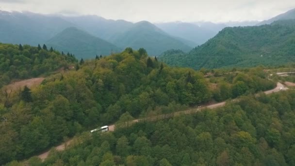Un autobús que viaja por una carretera de montaña, disparado desde el aire — Vídeo de stock