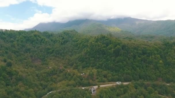 Um ônibus viajando em uma estrada de montanha, tiro do ar — Vídeo de Stock