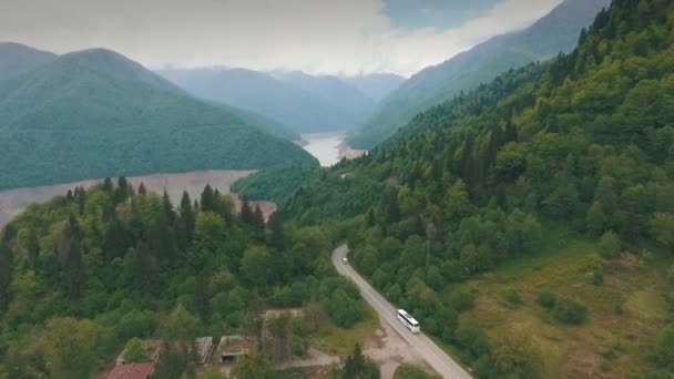 Un autobús que viaja por una carretera de montaña, montaña, fotografía aérea, disparos desde un helicóptero — Vídeos de Stock