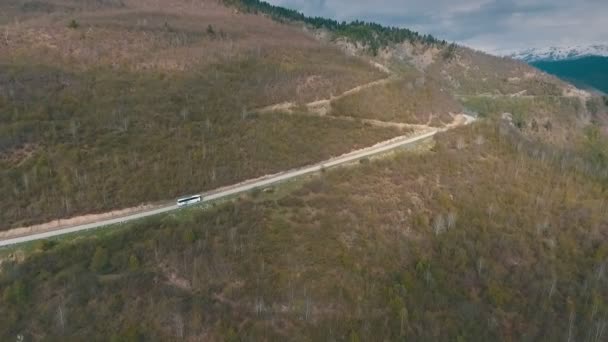 Um ônibus viajando em uma estrada de montanha, tiro do ar — Vídeo de Stock