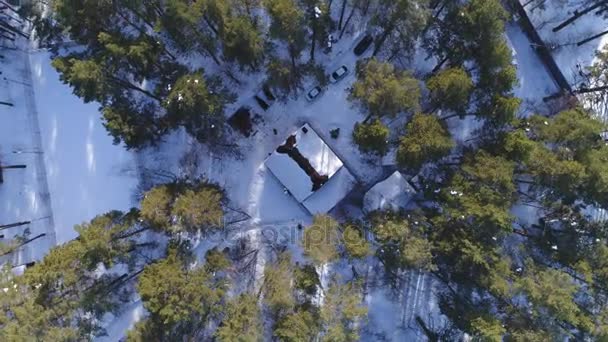 Luftaufnahme eines schneebedeckten Hauses im Wald — Stockvideo