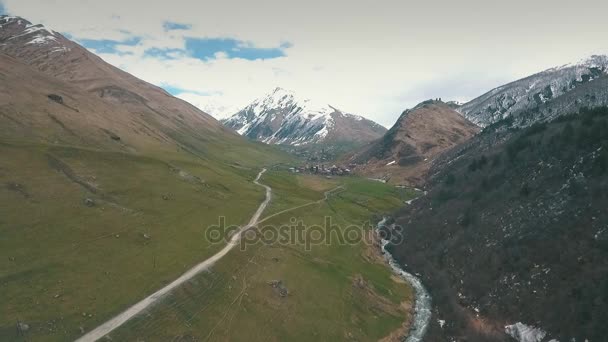 Estrada sinuosa em montanhas, montanhas no fundo, atirando com o drone — Vídeo de Stock