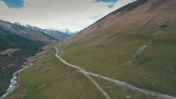 Estrada sinuosa em montanhas, montanhas no fundo, atirando com o drone — Vídeo de Stock