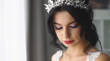 gelin düğün buket ile dışarı belgili tanımlık pencere ve kameraya gülümseyen görünüyor