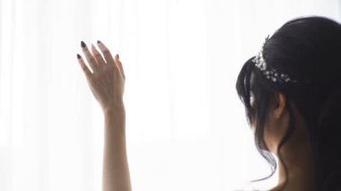 Odaya girmek sıcak yaz için bir pencere perde çekiyor el