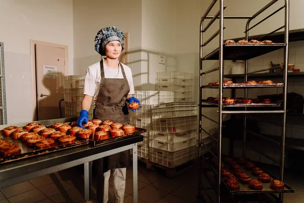 Bäcker steht morgens in seiner Bäckerei und backt Brot oder Brötchen — Stockfoto