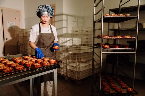 Bäcker steht morgens in seiner Bäckerei und backt Brot oder Brötchen — Stockfoto