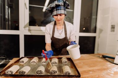 Kız ev yapımı çörekler, dilimlenmiş rulo hamur rulo yapar. Yukarıdan görüntülemek