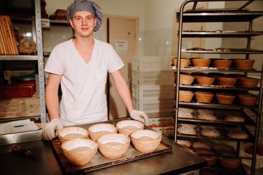 mutlu Baker kameraya bakarak ve gülümseyen ekmeği kalıplama