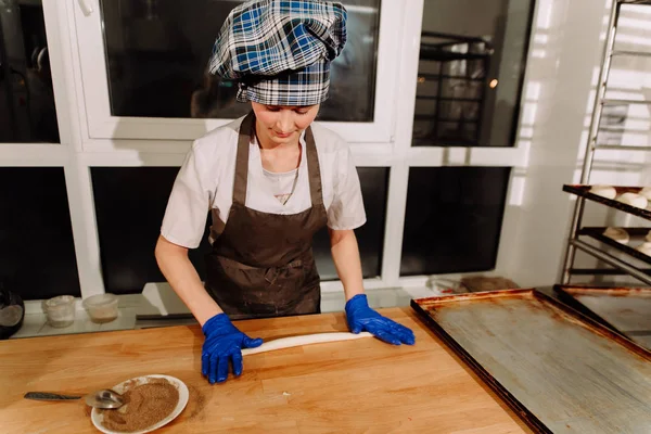 Kadın fırında pasta. Şekerlemeciler tatlılar olun. Çörekler yapma. Hamur masada